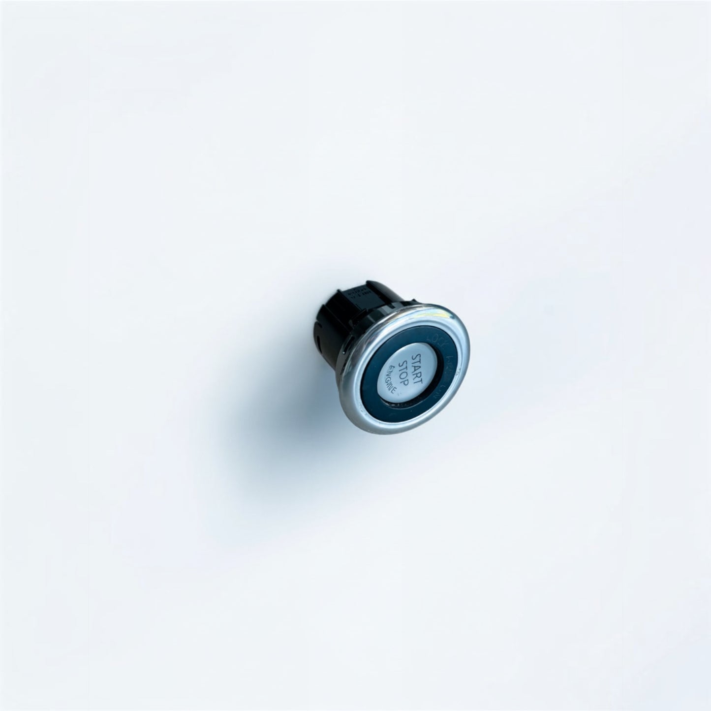 Outrageous Art car engine start stop button with a sleek silver metallic trim and black center on a white background