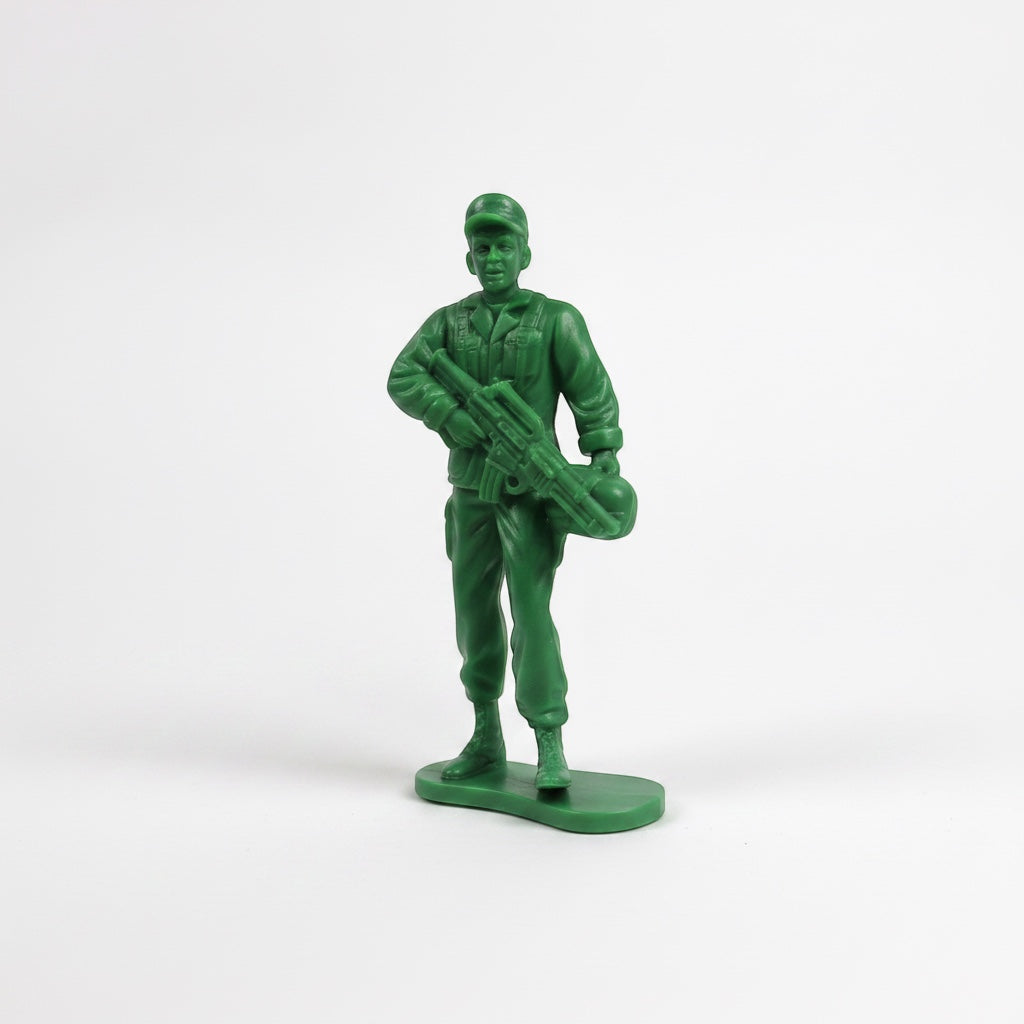 Outrageous Art classic green plastic toy soldier action figure holding a rifle on a white background