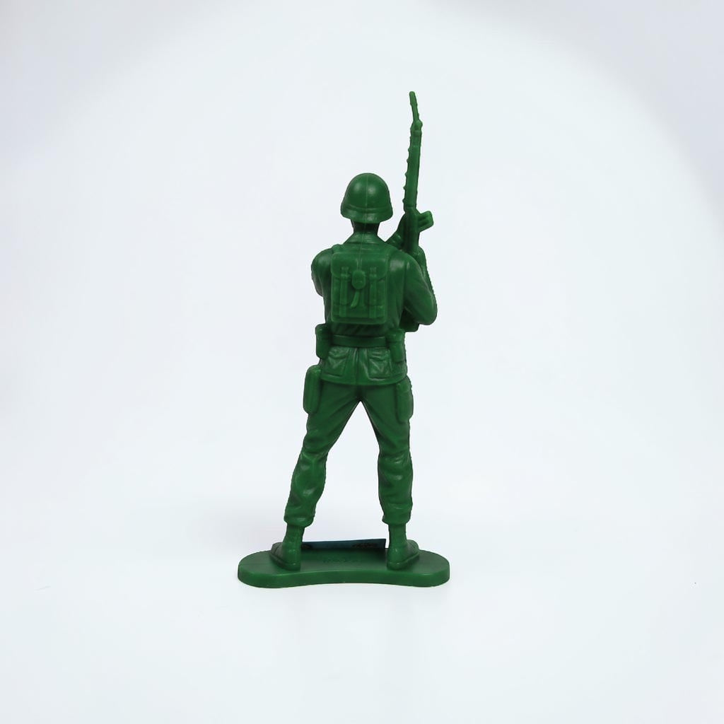 Outrageous Art green plastic toy soldier figurine with a rifle, shown from a rear view on a white background.