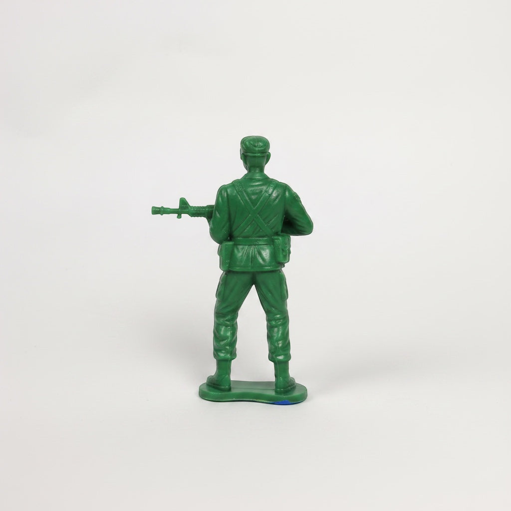 Outrageous Art green plastic toy soldier figurine holding a rifle, viewed from the back on a white background.