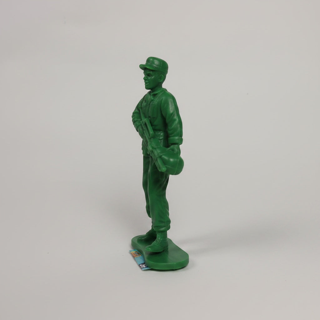 Outrageous Art classic green plastic toy soldier action figure standing on a base in a side profile view.
