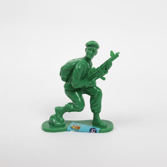 Outrageous Art green plastic toy soldier in a kneeling pose with a rifle and backpack on a white background