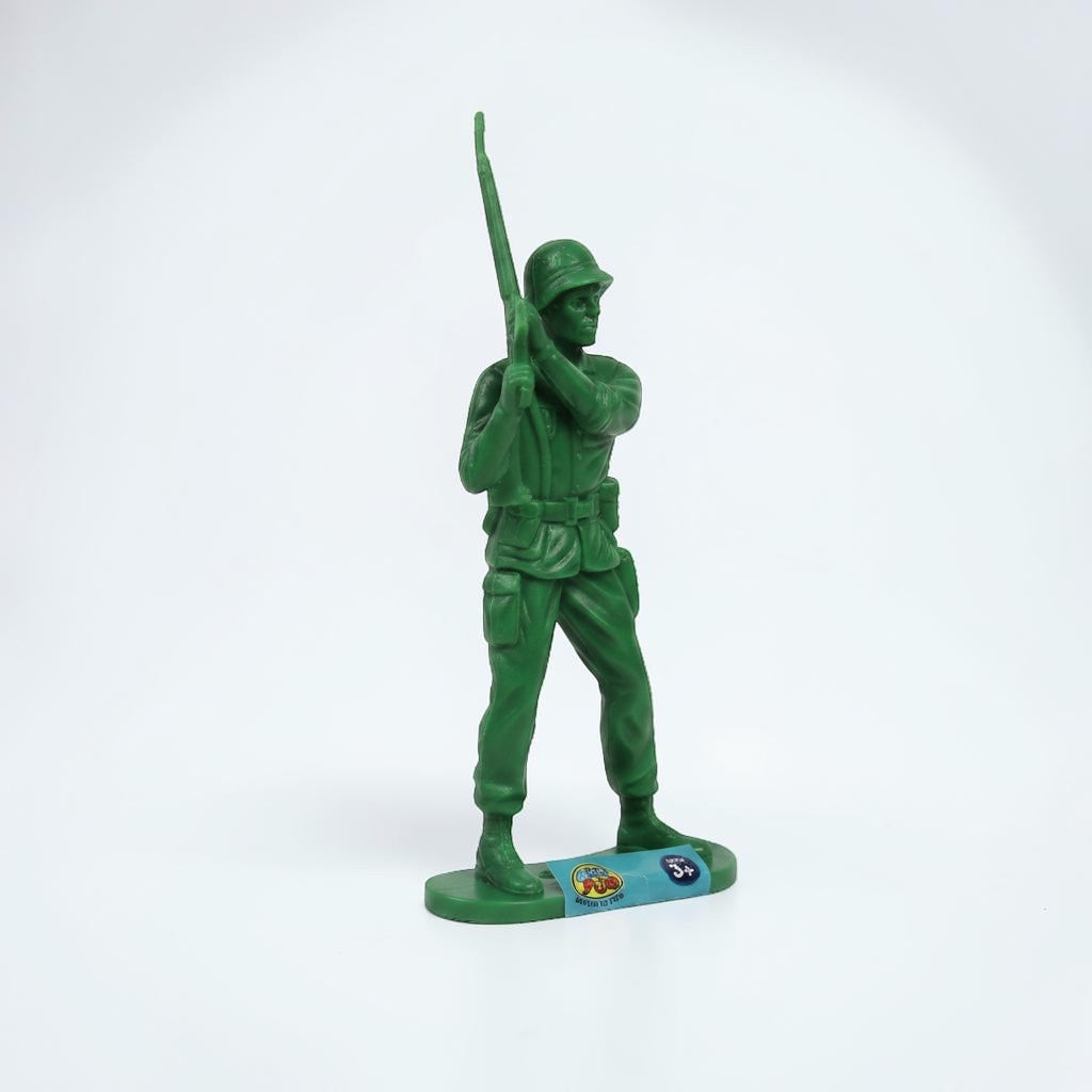 Outrageous Art green plastic toy soldier figurine standing in a military pose with a rifle on a white background