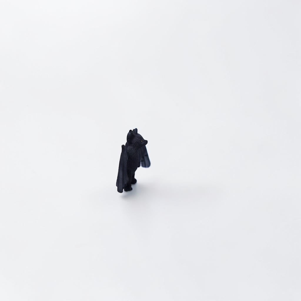 Outrageous Art miniature black bat figurine with detailed wings and realistic texture on a plain white background