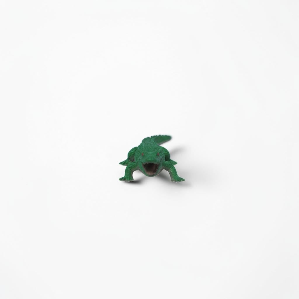 Outrageous Art miniature green alligator figurine with open mouth and textured scales on a white background