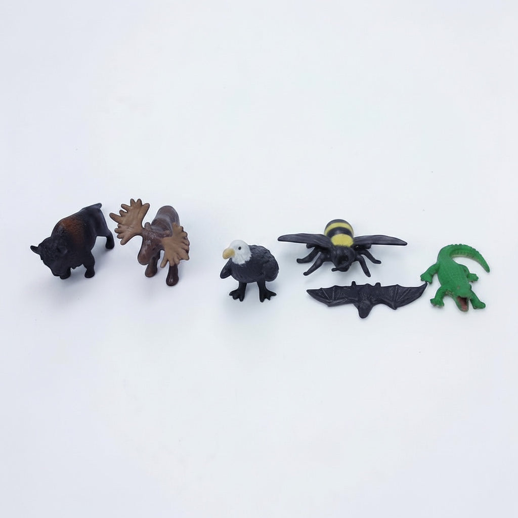 Outrageous Art miniature wild animal figurine set featuring a bison, moose, bald eagle, bumblebee, bat, and alligator.