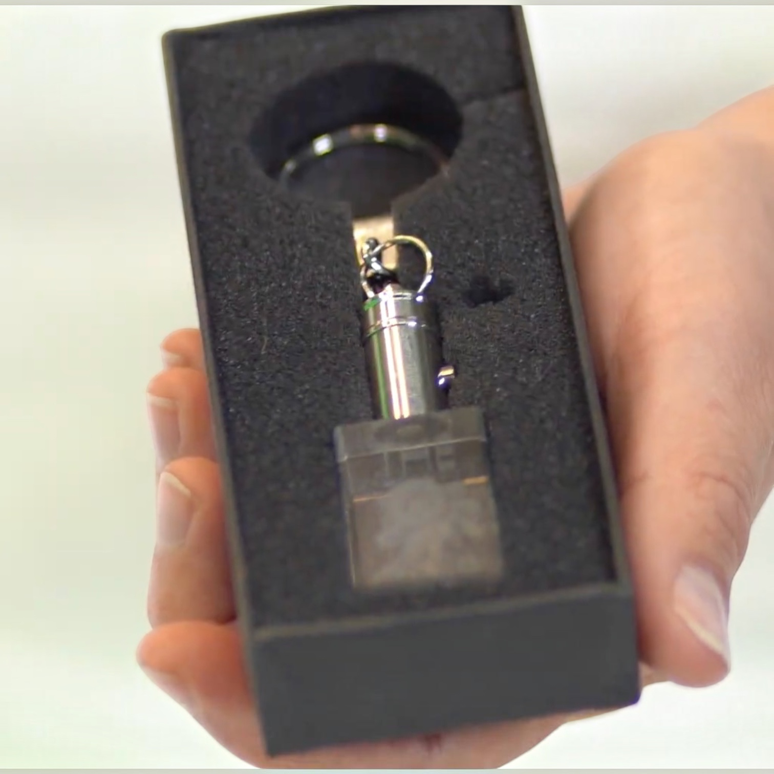 Outrageous Art O Club Keychain featuring a clear rectangular block and polished metal hardware in a black gift box.