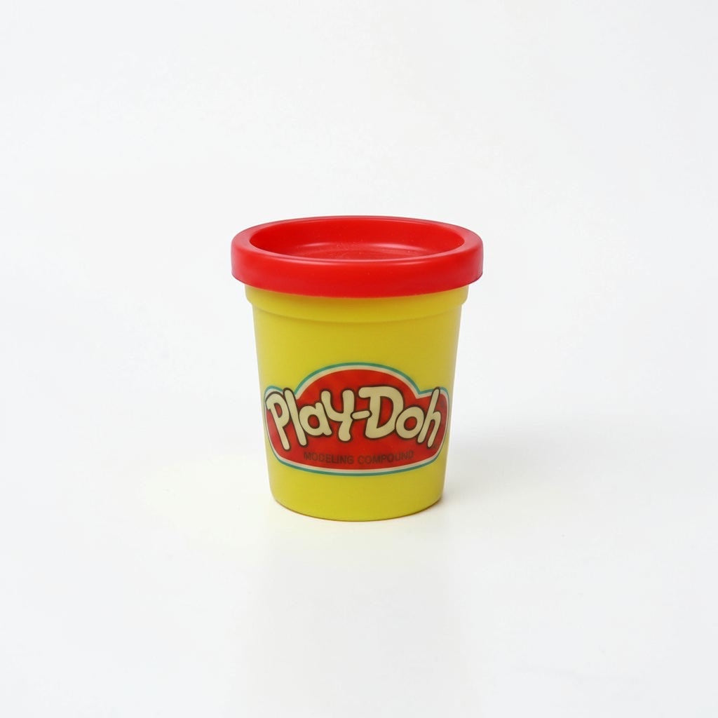 Outrageous Art Play-Doh modeling compound in a yellow container with a red lid on a white background