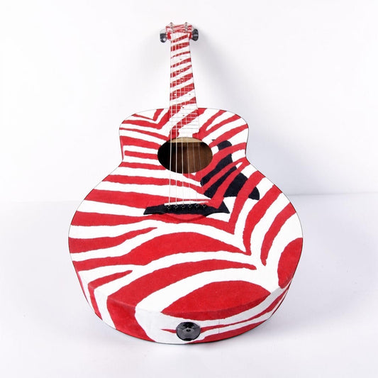 Outrageous Art velvet guitar featuring a bold red and white zebra stripe pattern on a unique sculptural instrument.
