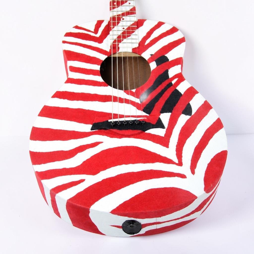 Outrageous Art velvet guitar featuring a bold red and white zebra stripe pattern on the body and fretboard.