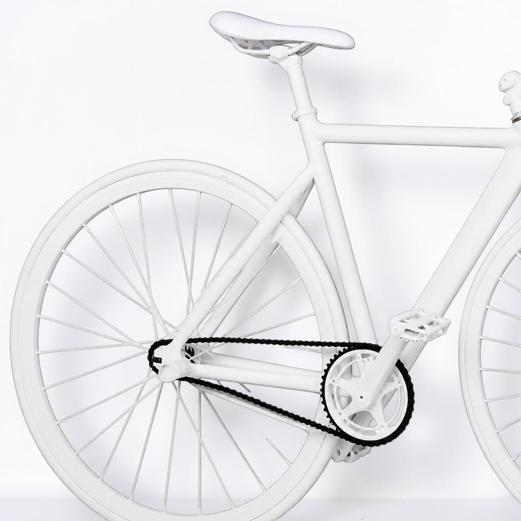Outrageous Art velvet bike in all-white with a sleek frame, white seat, and contrasting black chain for a bold look.